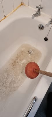 Emergency plumber clearing blocked drain in Bletchley
