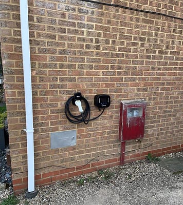 Electrician fitting a home electric vehicle charging point. Emergency electrician installing EV charger in Milton Keynes