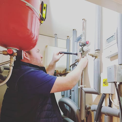 WhatsApp Image 2025-01-17 at 10.12.58 (2) Close-up of a plumber working on large industrial pipes in a domestic property